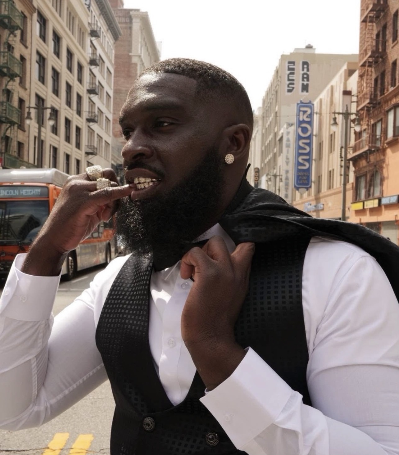The jeweler showing off his iced-out grillz and rings